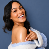 Woman wrapped in a blue towel against a solid background